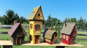 Four colorful birdhouses sitting together on a wooden bench outdoors.